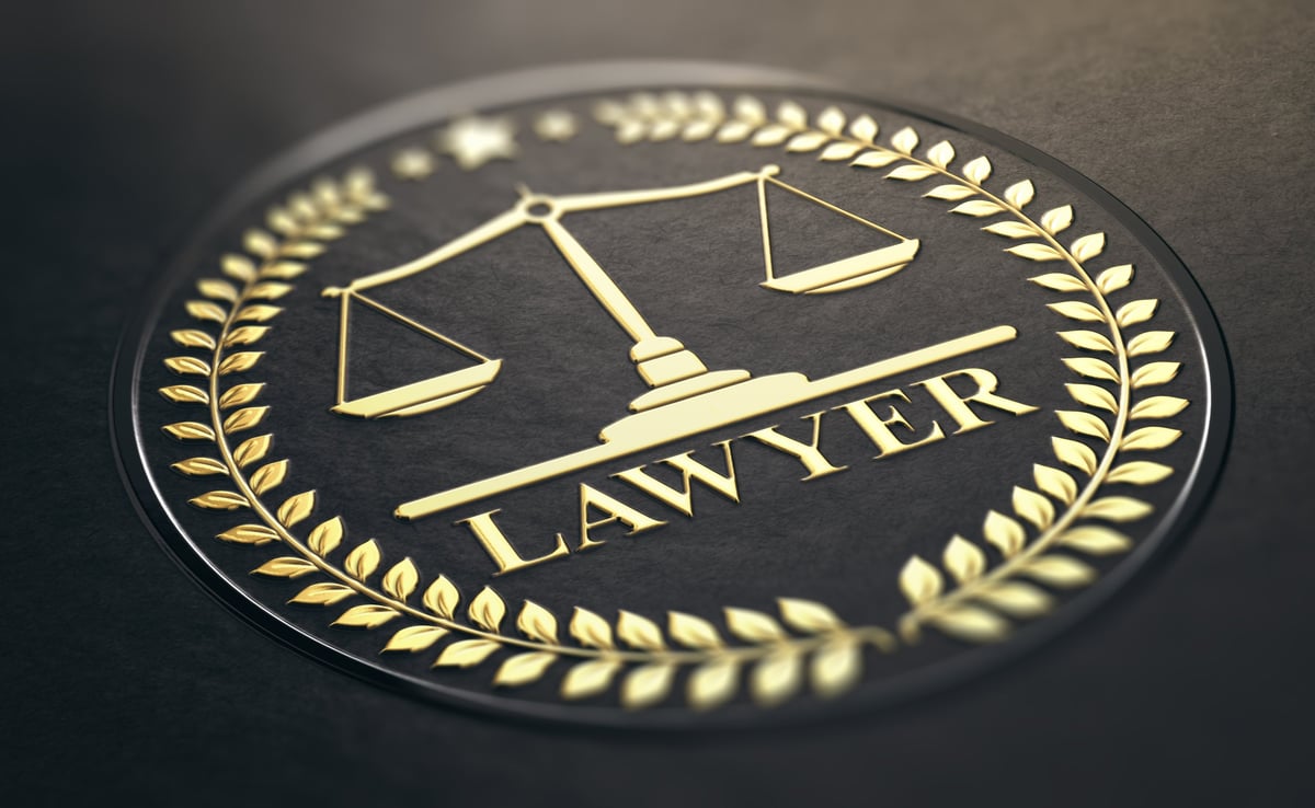 Golden stamp with scales of justice and laurel wreath on black paper