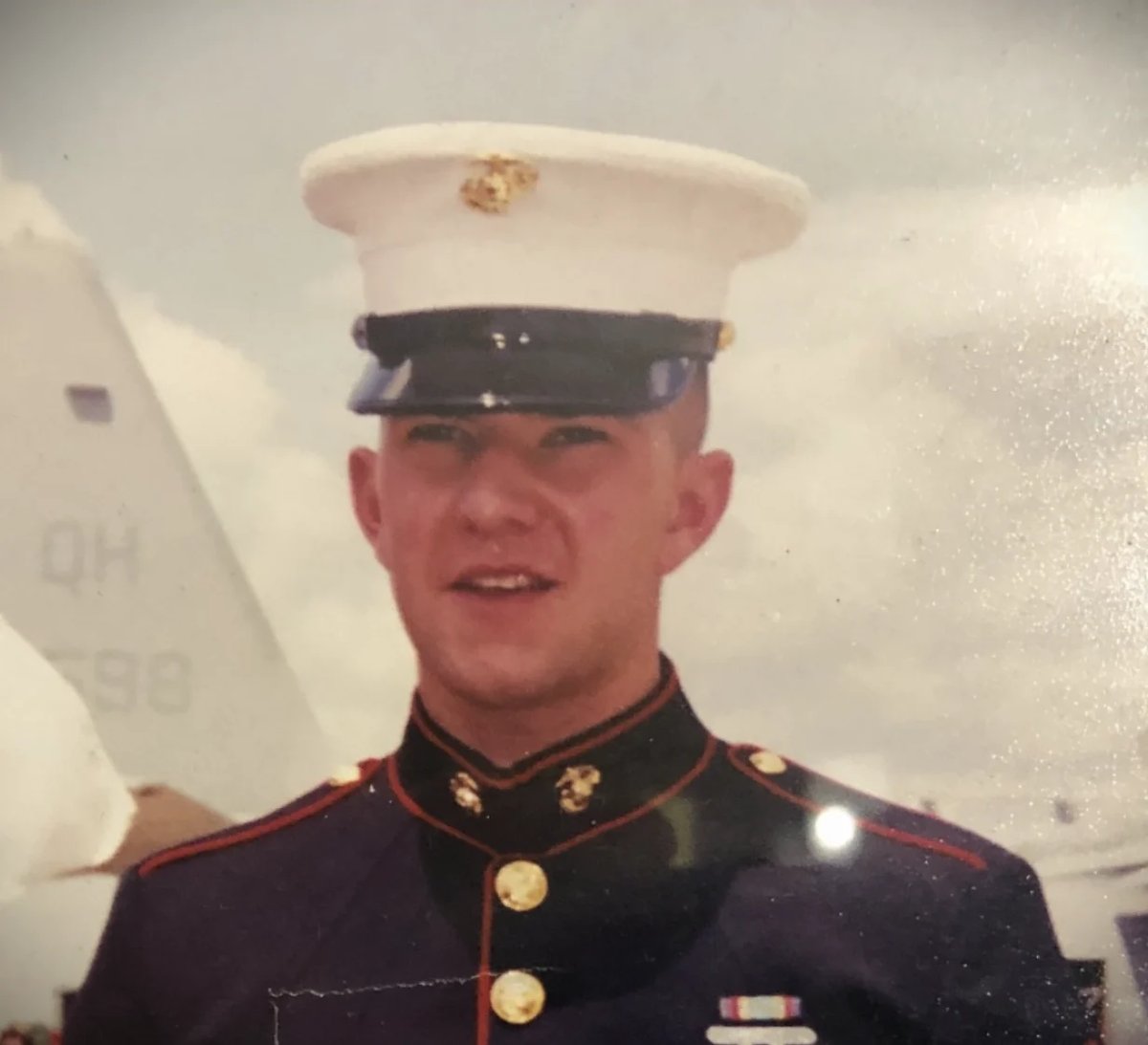 Portrait of a young man in U.S. Marine Corps dress uniform with white cover and insignia